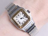 a silver and gold wrist watch on a woman ' s wrist