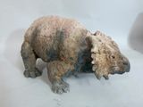 une statue représentant un ours assis sur une table