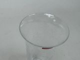 a clear glass with a red handle sitting on a table