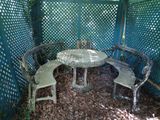 a table and four chairs in the shade of a pergol