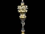 un gros plan d'un vase argenté et doré posé sur une surface noire