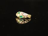 a gold ring with emerald, pink and green stones on a black surface
