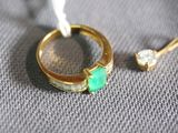 a gold ring with a green stone and a diamond