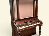 an old piano with a mirror on the top of it