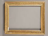 un cadre ancien doré avec un miroir accroché au mur