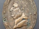 a close up of a bronze medallion with a man ' s face
