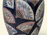 a blue vase with a fan design on it