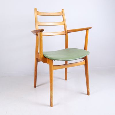 une image représentant une chaise en bois avec une assise verte posée sur un sol blanc