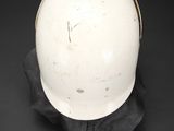 a white helmet on a black cloth on a black surface