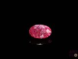 gros plan d'un diamant rose sur une surface noire