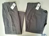 two men ' s pants with tags on them sitting on a table