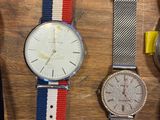 Plusieurs montres sont alignées sur une table en bois, parmi lesquelles une montre jaune