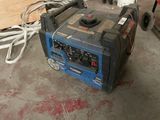 a blue and black generator sitting in a garage