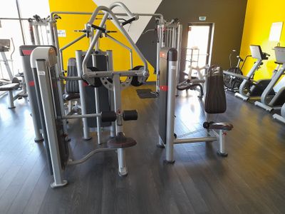une salle de sport équipée de nombreux appareils