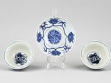 three pieces of blue and white porcelain with flowers on them