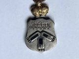 an image of a silver and gold charm with a crown on top