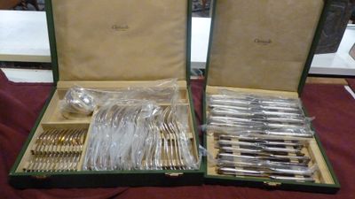 deux coffrets ouverts contenant de l'argenterie, posés sur une table