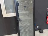 an image of a glass door refrigerator in a room