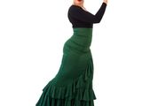 the woman is wearing a green skirt and black top