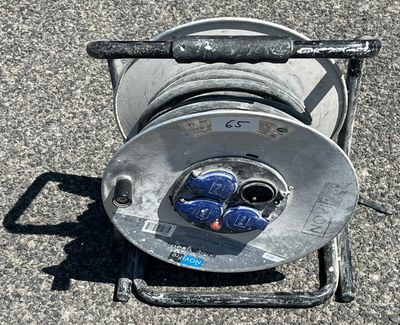 un tuyau fixé à un dévidoir posé au sol