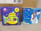 two children ' s books are sitting on a table next to a cardboard box