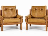 deux fauteuils en cuir marron, avec des pieds et des accoudoirs en bois, sur fond blanc