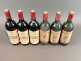 six bottles of wine lined up in a row on a table
