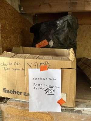 a cardboard box with a sign on it sitting in a pile of boxes