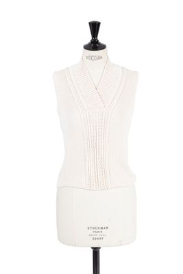 le haut d'un mannequin vêtu d'un pull blanc, posé sur un support de mannequin