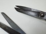 two pairs of scissors sitting on a white surface