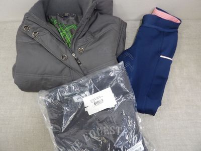 une veste et un pantalon posés sur un canapé, à côté d'une paire de chaussettes