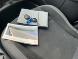 a book and a pair of scissors on the seat of a car