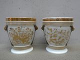 une paire de vases blancs et dorés posés sur une table