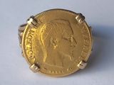 une image représentant une bague en forme de pièce d'or sur laquelle figure le visage d'un homme