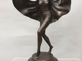 statue en bronze représentant une femme vêtue d'une cape, posée sur un socle