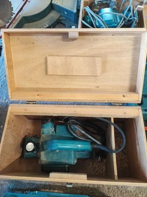 une boîte posée par terre, contenant une perceuse