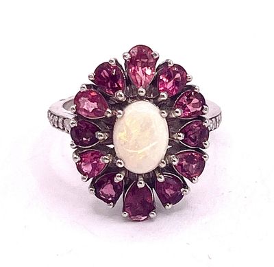 an image of a ring with a white oplite surrounded by pink sapphires