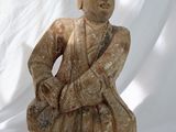 statue représentant un homme assis par terre, coiffé d'un chapeau