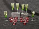 six gobelets et verres en verre vert et rouge posés sur une table