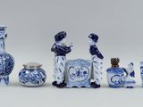 several blue and white vases and a picture frame on a white surface