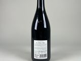 the bottle of wine is empty on a white surface