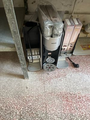 une cafetière posée par terre à côté d'une pile de cartons