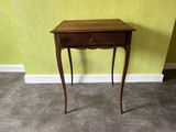 a small wooden table with a drawer on top of it
