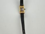a close up of a watch on a white surface with a black strap