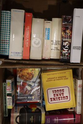 une boîte remplie de livres posée sur une étagère, à côté d'une tasse à café