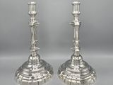 pair of silver candlesticks on pedestal on grey background