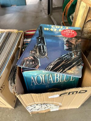 une boîte pleine de livres posée sur le sol
