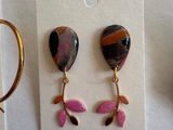 several pairs of earrings and a pair of scissors sitting on a table