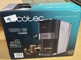 La boîte d'une cafetière est ouverte sur la table.