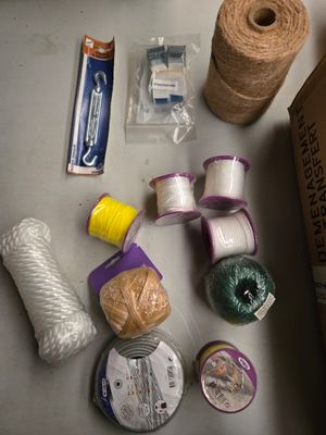 une table sur laquelle se trouvent plusieurs objets, notamment un rouleau de ficelle, une bobine de ficelle et une bobine de ficelle double